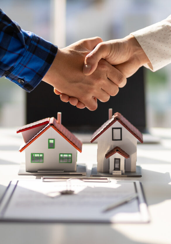 Real estate agents shake hands after the signing of the contract agreement is complete.