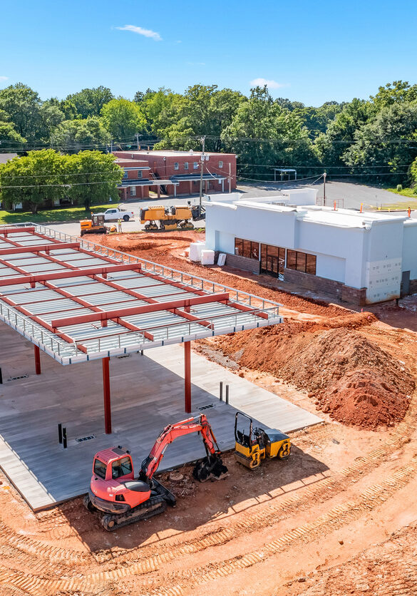 Construction site for a new gas station showing fresh dirt and unfinished building, unfinished parking lot and unfinished fuel island